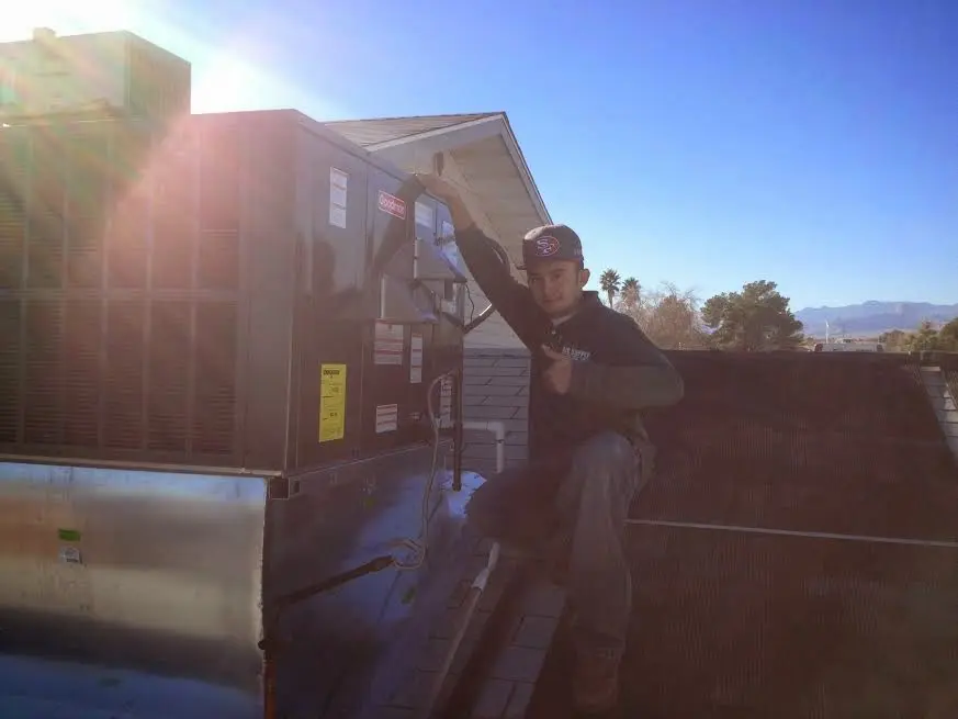 HVAC technician performing Heat Pump Repair on a rooftop unit in White Hall